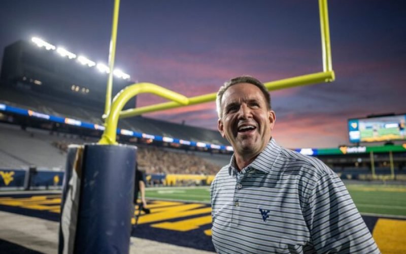 WVU President Michael Benson laughs after throwing a football during Sunday Night Lights at Milan Puskar Center, August 17th, 2025. (WVU Photo/Brian Persinger)
